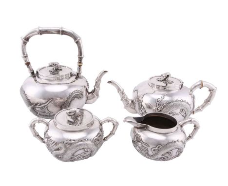 A Chinese silver four piece tea set by Wang Hing, late Qing, the covers with knops in the form of a prunus branch and blossom