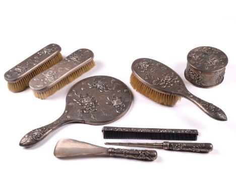 A Chinese silver eight piece dressing table set, marked for Sincere, late Qing, each piece with embossed spider chrysanthemum