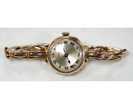 A lady's early 20th century 9ct gold manual wind wrist watch, with Arabic dial, on a 9ct expanding bracelet, gross weight 21.