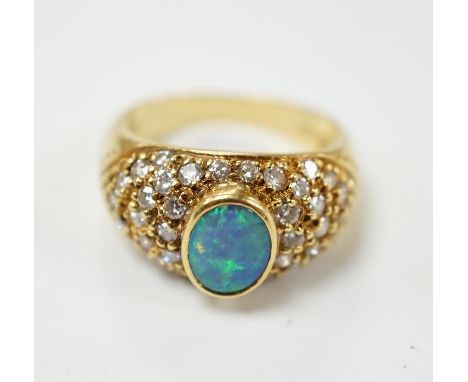 A modern 750 yellow metal and back opal set dress ring with diamond cluster set shoulders, size L, gross weight 6.9 grams. Co