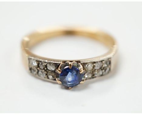 An early 20th century yellow metal (stamped 18) and single stone sapphire set ring, with twelve stone diamond chip set should