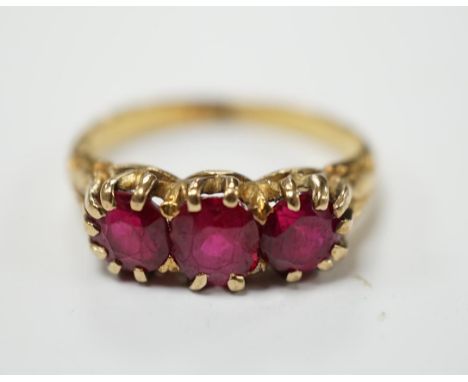 A yellow metal and three stone synthetic ruby set ring, size M, gross weight 4.8 grams. Condition - fair