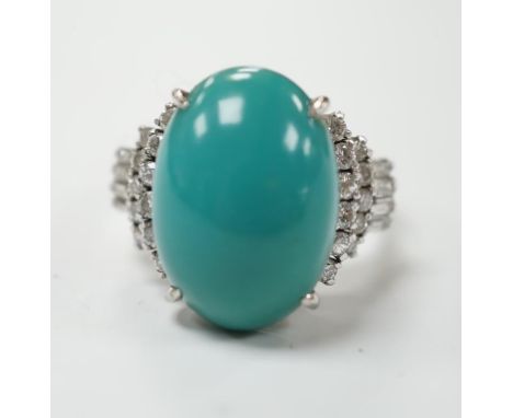 A modern white metal (stamped Pt900) and cabochon turquoise set dress ring, with baguette and round cut diamond set shoulders