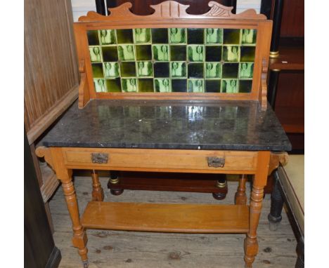 An Art Nouveau black marble top washstand with green back tiles, width 40", depth 18" and height 44" (all measurements approx