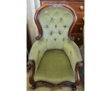 A carved Mahogany spoon back armchair on scroll legs upholstered in green button back draylon