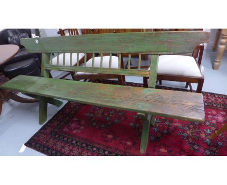 An antique pine garden bench in old green paint, x-framed, to provide low backed sitting position. Ideal against garden wall 
