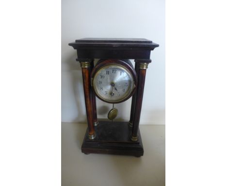 An ebonised cased Portico clock, Arabic numerals to silvered dial