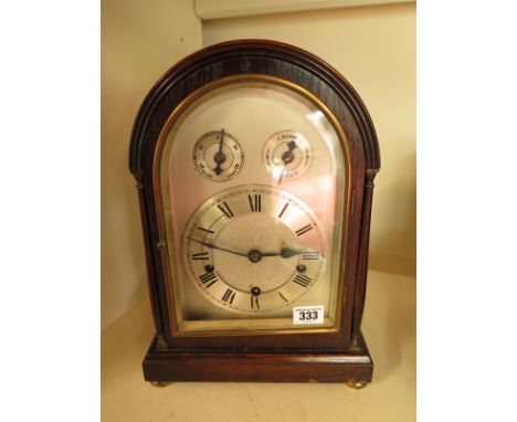 An oak cased bracket clock with Roman numerals to silvered dial