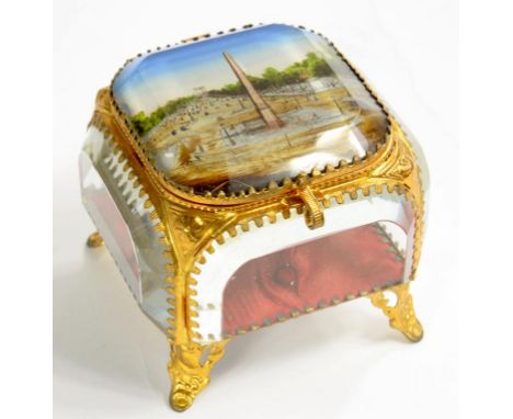 A PALAIS ROYAL EMBOSSED GILTMETAL JEWEL CASKET WITH PLUSH LINED CUSHION AND  BEVELLED GLASS SIDES, THE LID WITH PARIS VIEW, 7