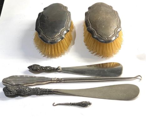 Selection of silver items includes  silver back brushes button hook and shoe horns 