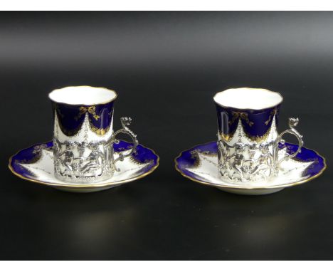 A pair of Coalport silver mounted cabinet cups and saucers. Chester 1911. Cup 6.8 cm high. Saucer 12 cm in diameter. UK Posta
