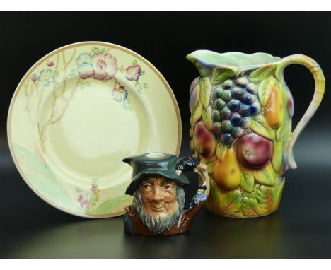 A Sylvac jug, Clarice Cliff plate "Chippendale Trees" and a Royal Doulton Rip Van Winkle character flask D6463. Plate 22.5 cm