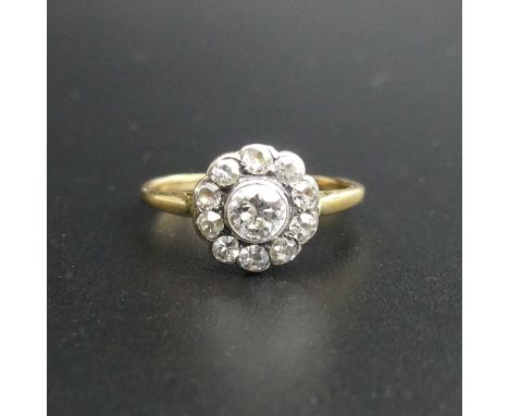 18 carat gold and diamond cluster, the clean bright centre stone is approx. 4.5 mm in diameter. Size K 1/2. 2 grams. UK Posta