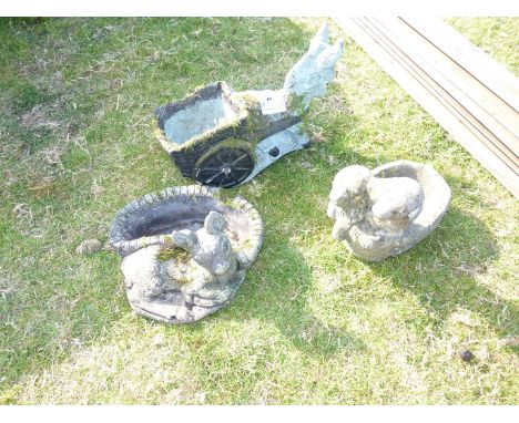 Three concrete garden ornaments.