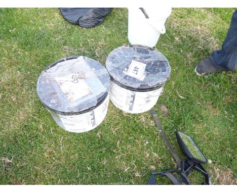Two tubs of tile cement.