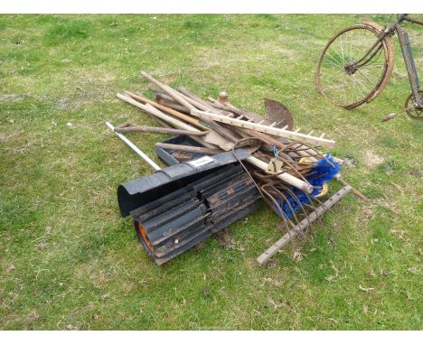 A quantity of tools including a pitch-fork, shovels, spades, forks, a distance measuring wheel, a Stihl rotary sweeper attach