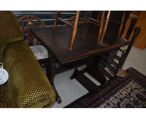 A dark stained Ercol style drawer leaf dining table