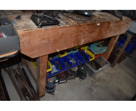 A pine work bench having fixed black and decker drill and under shelf