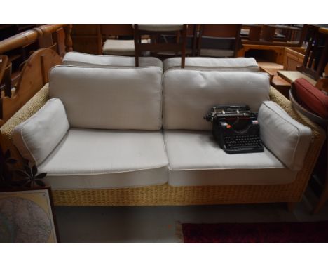 A pair of Rattan frame settees, look very nice quality and only a few light marks to the cream upholstery.would be suitable o