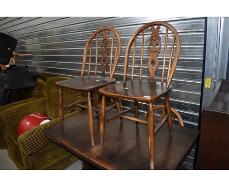 A set of four dark stained Ercol 'fleur de lys' kitchen chairs, dimensions approx H82(seat 43) W40, D40cm