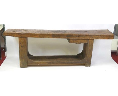 An antique oak and elm potter's bench, probably 18th century and later, the heavy one-piece top having cleated ends, over a f