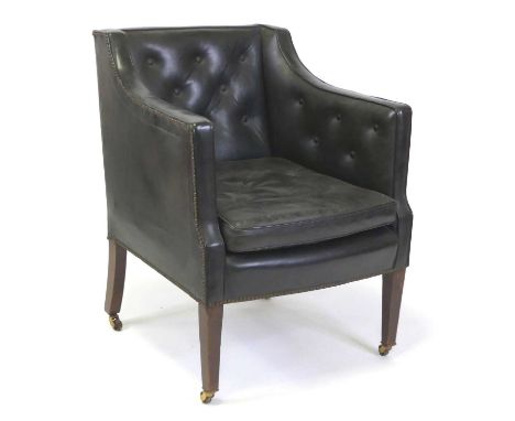 A late Victorian mahogany and black leather library armchair, having button back black leather upholstery with squab cushion,