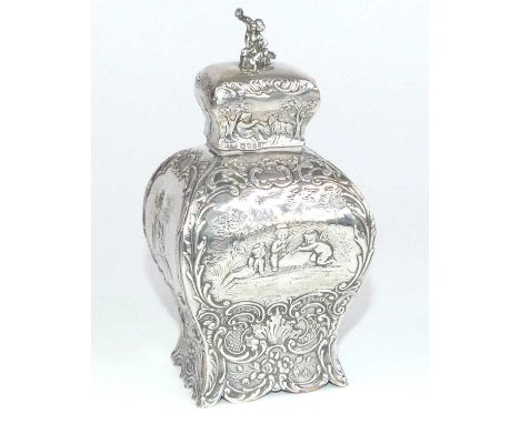 A circa 1900 German silver tea caddy, of shouldered rectangular form upon a scrolling foot, all-over repousse decorated with 