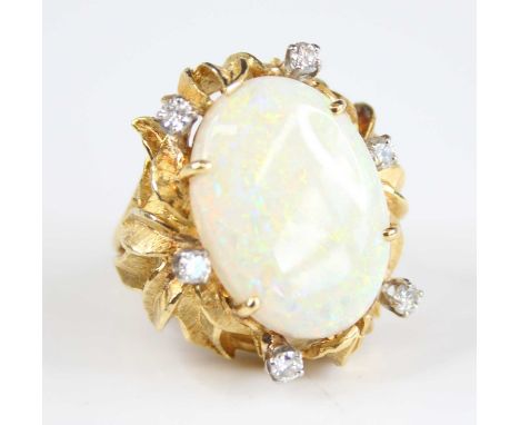 An 18ct gold opal and diamond abstract cluster ring, the centre oval opal cabochon measuring approx 21.5 x 15.5 x 4.9mm and e
