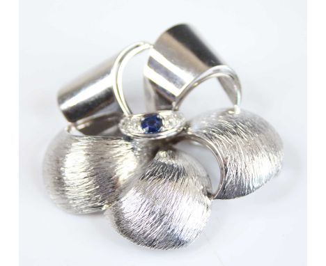 A contemporary 18ct white gold, sapphire and diamond flower brooch, having three textured and two polished petals, the centra