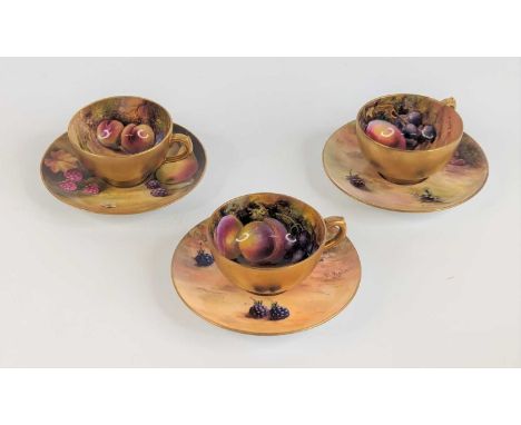 A set of three Royal Worcester miniature tea cups and saucers, circa 1925, hand painted with fruit and signed by William Hale