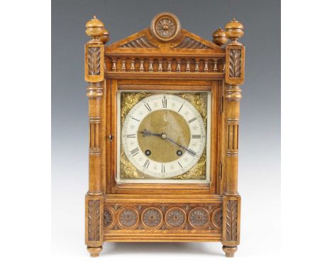 A late Victorian walnut and burr walnut cased bracket clock, the Aesthetic Movement influenced architectural case enclosing a