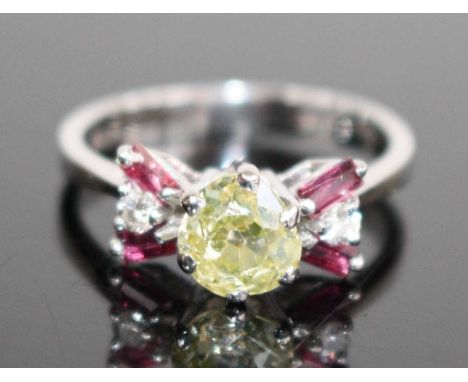 A white metal diamond and ruby fancy bowtie style dress ring, featuring a centre Old European cut fancy light yellow diamond 