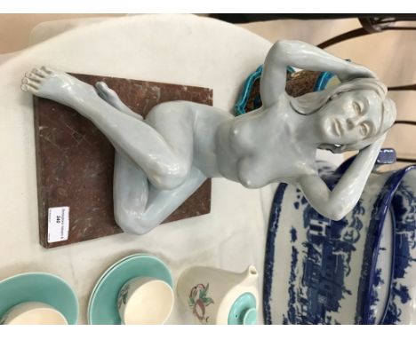 A ceramic nude figure on a marble base