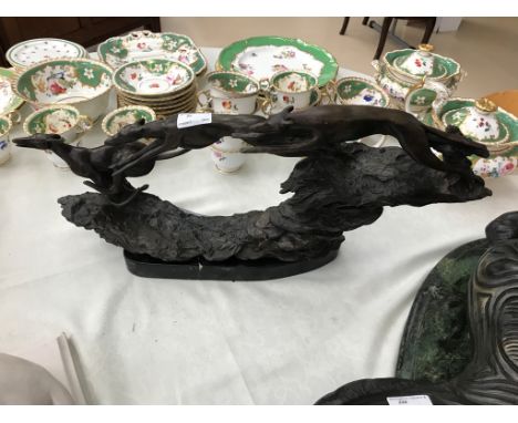 A bronze modelled as three greyhounds running on a slate base