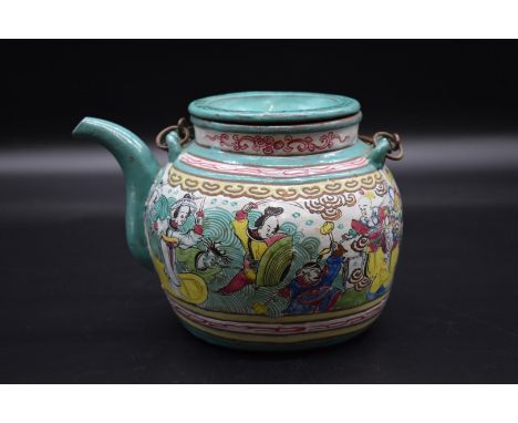 A Chinese yixing enamel teapot and cover, 19th century,&nbsp;painted with a continuous scene of figures, 15cm high. 