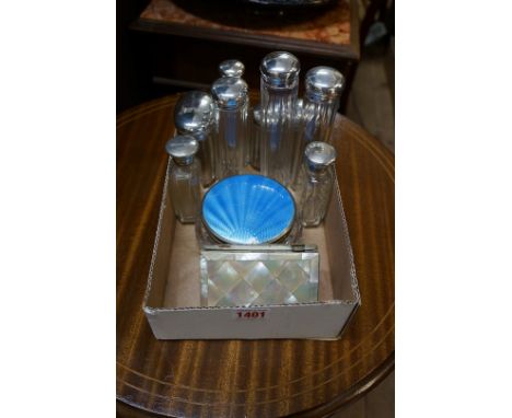 A collection of silver lidded toilet bottles;&nbsp;together with a guilloche enamel lidded jar; and a mother-of-pearl card ca