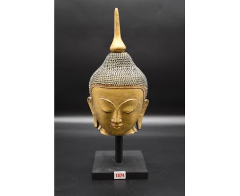 A Sino-Tibetan gilt pottery Buddha's head,&nbsp;probably 19th century, height including gilt wood finial 34.5cm, on black pai
