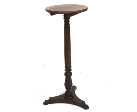 A Victorian rosewood and mahogany torchiere stand. The circular top mounted on a carved and reeded column, with a tripod supp