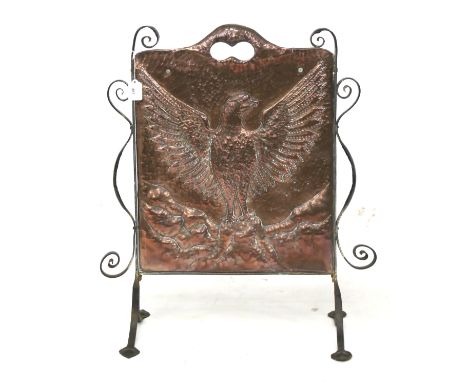 An Arts and Crafts copper and wrought iron firescreen. The copper panel embossed with an eagle with outspread wings, H75cm Co