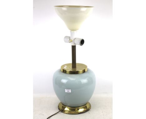 A contemporary table lamp. Of bulbous form, the glue glass reservoir placed on a brass base, with a white enamel shade, H69cm