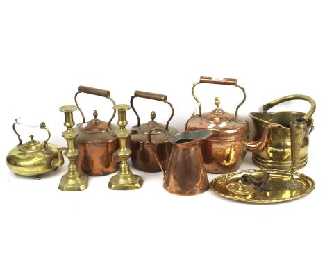A collection of assorted vintage copper and brass items. Including three copper kettles, a pair of candlesticks, etc.