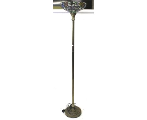 A Tiffany style standard lamp. The leaded glass shade featuring floral details and foliage, mounted on a fluted metal column 