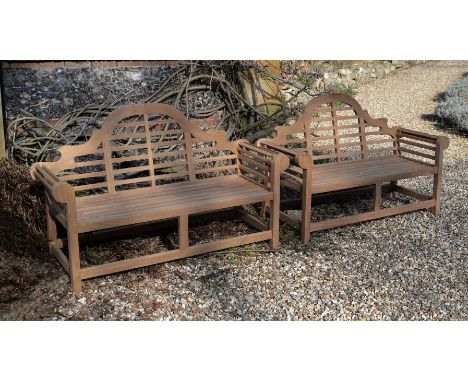 A pair of teak garden benches, of recent manufacture, in the manner of designs by Lutyens, the arched and serpentine backrest