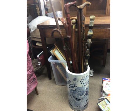 A collection of walking sticks including a horn walking stick in a 20th Century Chinese blue and white e port porcelain stick