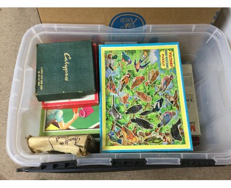 A box of various vintage board games.
