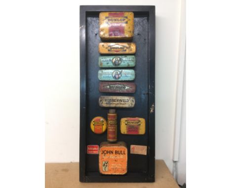 A mounted display of twelve vintage puncture repair kits. Shipping category C.