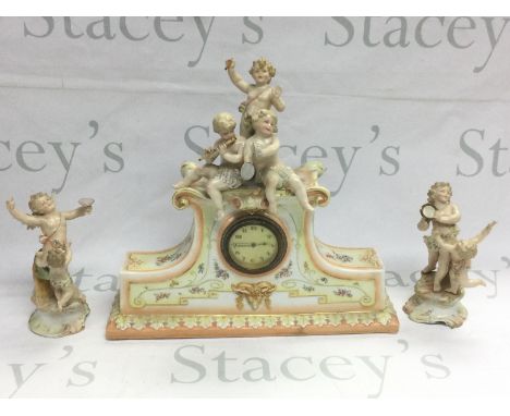 A Continental porcelain mantle clock surmounted with three cherubs and a pair of cherub clock garnitures (3). Shipping catego