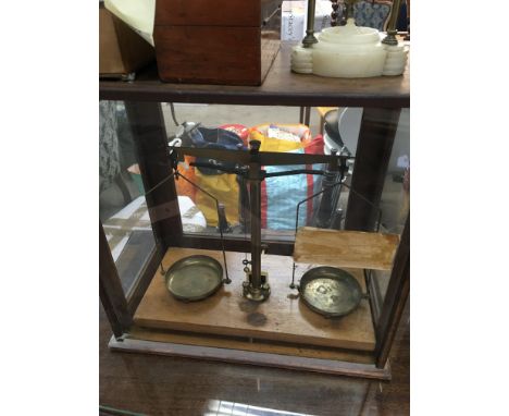 A set of balance scales together with boxed weights and a ball clock .