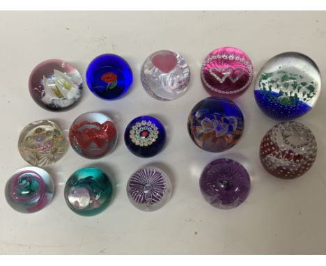 A collection of Caithness and other paperweights.