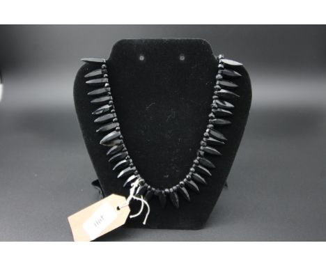 Black stone necklace, light blue satin purse